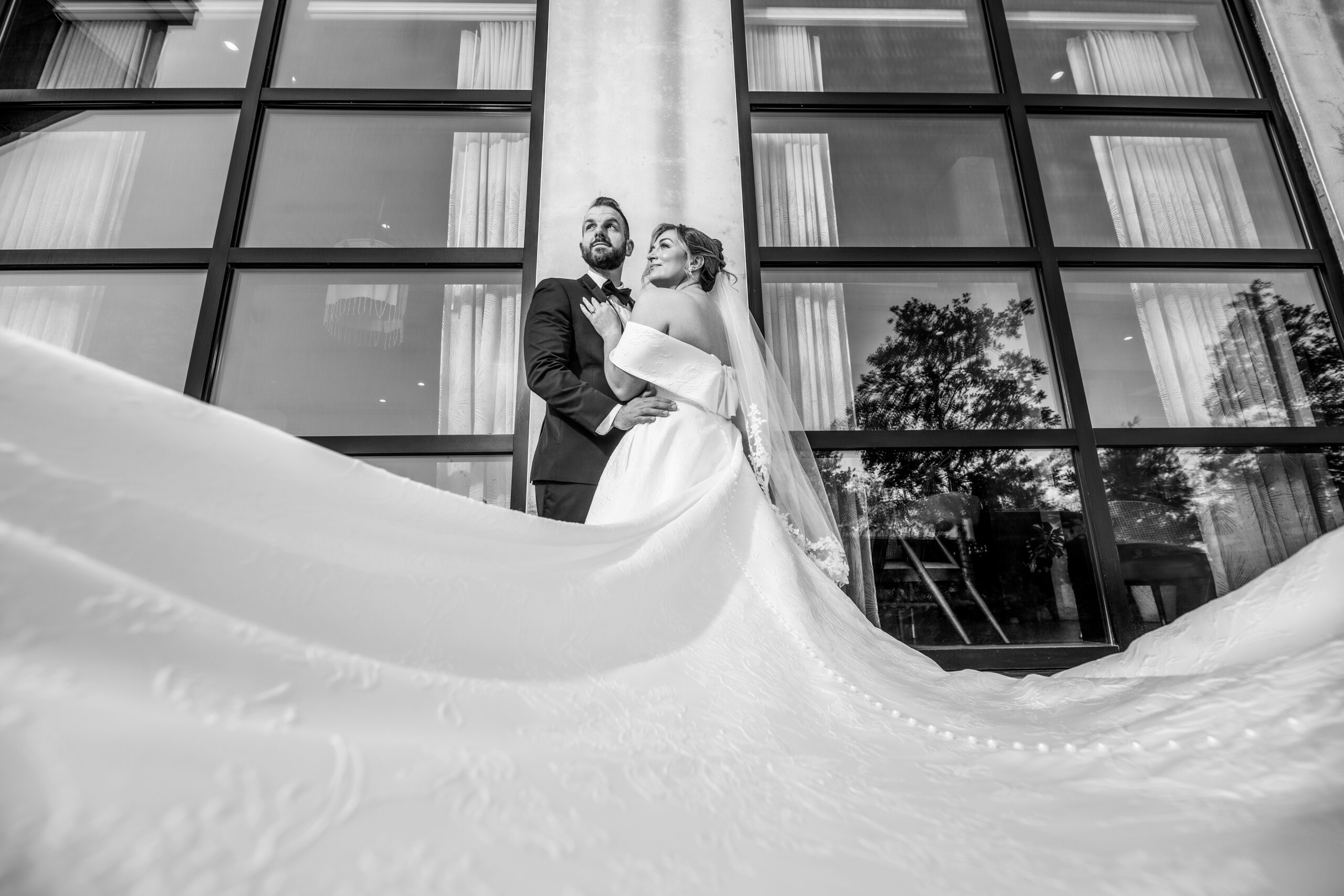 Bride standing in front of groom with the train of her dress spread out beautifully