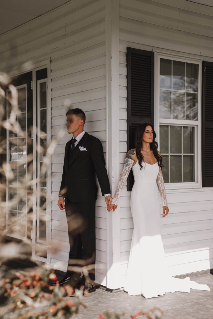Emotional pre-ceremony “first touch” moment as Amanda and Garren stand back-to-back holding hands, highlighting the intentional planning by their trusted wedding vendor team.