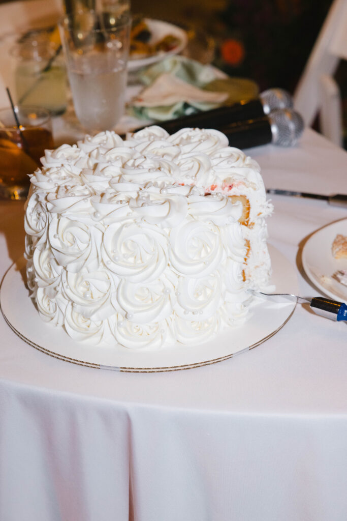Single-tier buttercream rosette cake with pearl accents, showcasing a stylish alternative in the wedding cake vs dessert table choice.