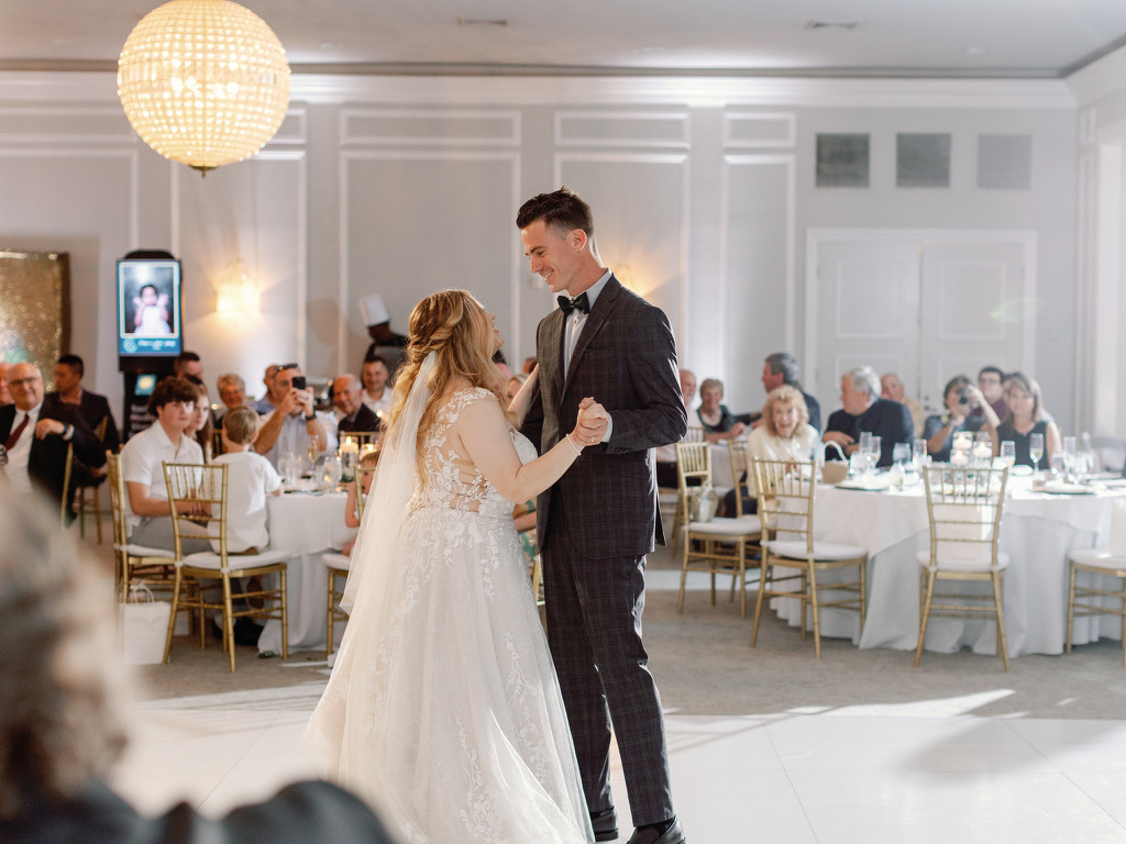 Delightful Event Planning newlyweds first wedding dance in front of wedding guests during reception.