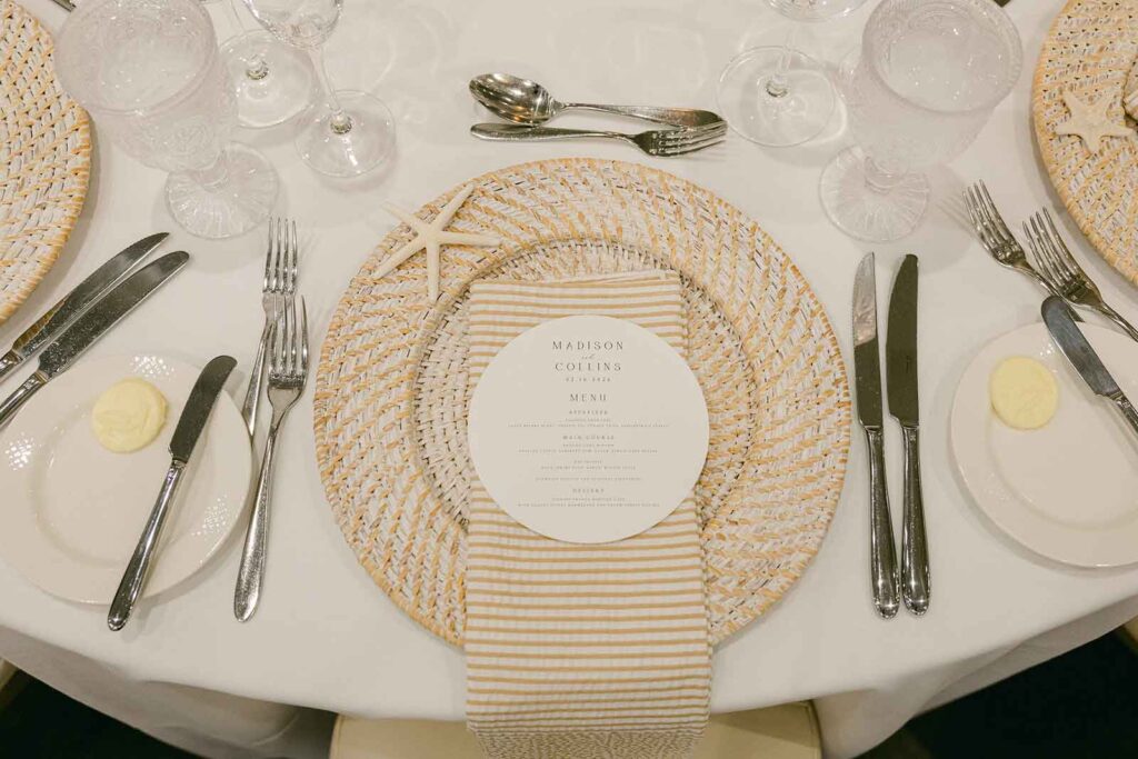 Coastal inspired wedding table setting with woven charger and neutral tones at Pelican Club Jupiter