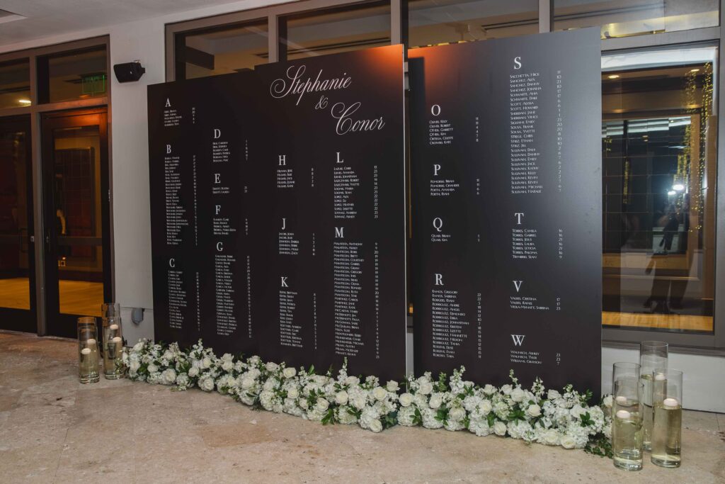 Modern black wedding seating chart with white florals at Marriott Harbor Beach